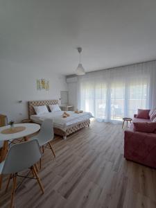 a bedroom with a bed and a couch and a table at RIO Residence in Soko Banja