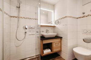a bathroom with a shower and a sink and a toilet at Bergblick - der Gasthof in Riezlern