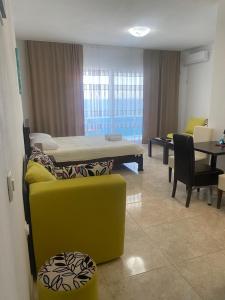 a room with a bed and a table and chairs at Apartments Delfin in Bar +19 photos