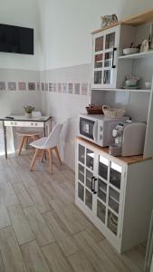 a kitchen with white cabinets and a table at Il Nido del Vicolo in Città della Pieve