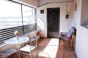 a balcony with a table and chairs and a door at Acqua Flats Jaguariúna in Jaguariúna
