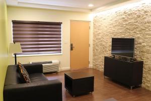 a living room with a couch and a flat screen tv at Curtis Inn & Suites in Hollywood
