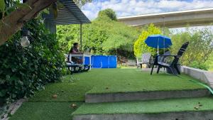 a person sitting at a table in a garden at Green cabin in our small garden in Arruda dos Vinhos