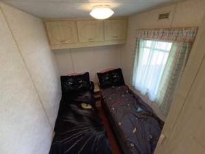 two beds in a small room with a window at Nad Łabędzim Stawem in Dratów