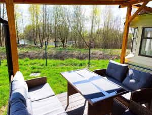 a screened in porch with a table and a couch at Nad Łabędzim Stawem in Dratów