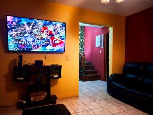 a living room with a flat screen tv on the wall at Casa Mary's in Quetzaltenango