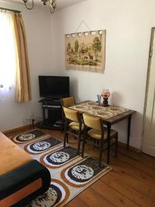 a room with a table and chairs and a television at Leśniczówka Turowo - Podlasie in Nowosiółki