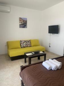 a living room with a yellow couch and a table at Apartments Delfin in Bar