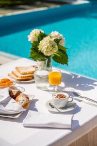 a table set for breakfast next to a swimming pool at UNITY BANK HOTEL Termale Padova RC12 in Abano Terme