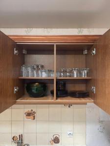 a kitchen cabinet filled with glasses and dishes at Maison charmante in Le Mans