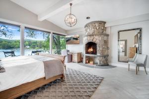 a bedroom with a fireplace and a bed and a chair at Waterfront Lakehouse in New Fairfield