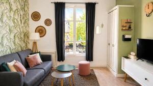 a living room with a couch and a window at We Sea in Deauville