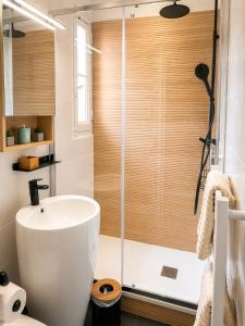 a bathroom with a shower and a white sink at We Sea in Deauville