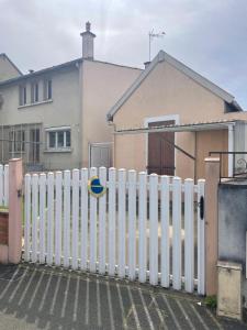 a white fence in front of a house at Maison charmante in Le Mans