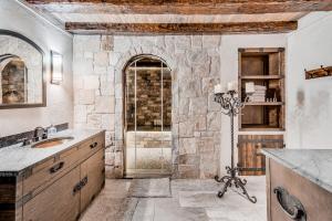 a bathroom with a sink and a stone wall at Waterfront Lakehouse in New Fairfield +66 photos