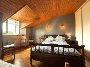 a bedroom with a bed with a wooden ceiling at Haramburua in Macaye