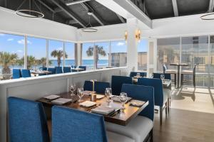 a dining room with a table and chairs and windows at Lovely Oceanfront King Room 5th Flr in Pawleys Island +17 photos