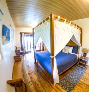 a bedroom with a canopy bed in a room at Red Frog Bungalows Ocean Resort in Short Cut