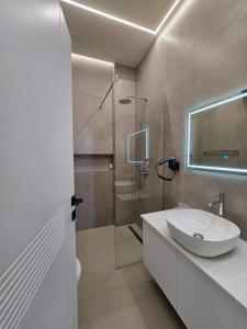 a bathroom with a sink and a glass shower at Suites By Jordan's Hotel in Vlorë +47 photos