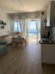 a kitchen and dining room with a view of the ocean at vinaka in SantʼAlessio Siculo