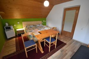 a bedroom with a wooden table and a bed at Guest House Žnidar in Bohinj