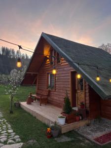 a small wooden house with a porch and a bench at EscapeTinyCabin by IezerVenture in Lereşti