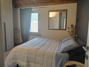 a bedroom with a bed and a window at Casina Borgo Castello in Civitella di Romagna