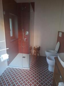 a bathroom with a glass shower and a toilet at CamElia in Garlenda