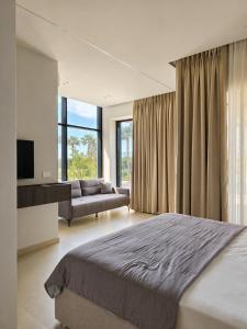 a bedroom with a large bed and a couch at Suites By Jordan's Hotel in Vlorë