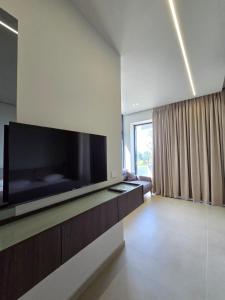 a living room with a large flat screen tv on a wall at Suites By Jordan's Hotel in Vlorë