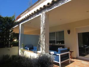 a screened in porch with two blue chairs in front of a house at Casa adosada en Calella de Palafrugell in Palafrugell