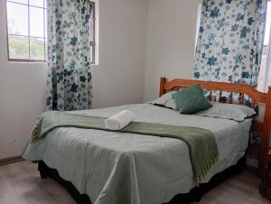 a bedroom with a bed with a green blanket and a window at Leisure Seaview House in Port Edward