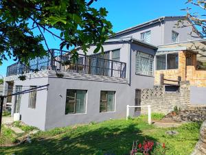 a large white house with a balcony at Leisure Seaview House in Port Edward