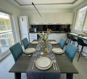 a dining room table with plates and glasses on it at Brand New Seafront Apartment in Sliema