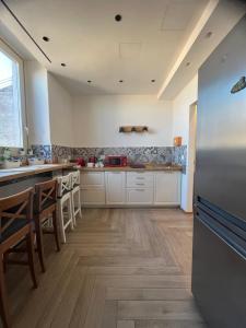 a kitchen with a stainless steel refrigerator and wooden floors at Ursino's Luxury in Catania