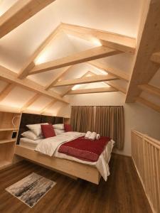 a bedroom with a large bed with wooden ceilings at Bohinj Mountain Dreams in Bohinj
