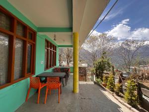 a table and chairs on the porch of a house at Blue Heaven Tosh in Tosh
