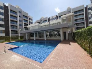 a swimming pool in front of a building at Cozystays by Vee Near JKIA in Nairobi