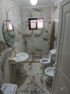 a bathroom with two toilets and a sink and a mirror at Roland Palaj House in Shkodër
