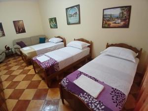 a room with three beds and a couch in it at Roland Palaj House in Shkodër