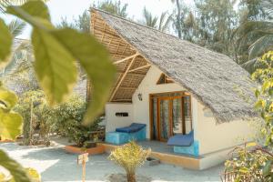 a small house with a thatched roof at Sunset Mkuu Boutique Hotel in Michamvi