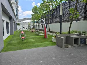 a playground on the side of a building with grass at PJ UM PacificStar Suite 2-3pax by DingDing in Petaling Jaya