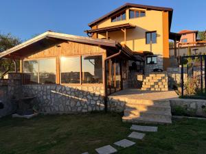 a house with a stone wall and a building at Villa Solina in Sapareva Banya