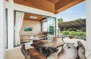 a living room with a wooden table and chairs at Anara Pool Villa - Private House in Bophut