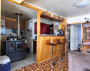a kitchen with a counter and a bar with stools at Donde Mauricio in Coihaique