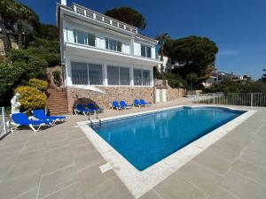 a house with a swimming pool in front of a house at Villa La Gavina Sea View Pool and Beaches in Blanes