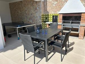 a dining table and chairs with a fireplace in a room at Villa La Gavina Sea View Pool and Beaches in Blanes