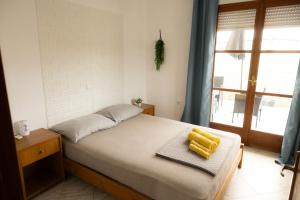 a bedroom with a bed with yellow objects on it at SteMaMaisonette in Afantou