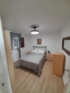 a bedroom with a bed in a white room at Alojamiento El Sevillano in Cullera