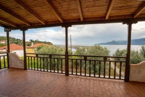 a covered porch with a view of the water at FantaSea Evgenia in Sampatiki